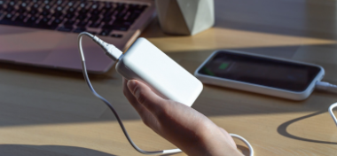 Person holding a power bank charging a smartphone