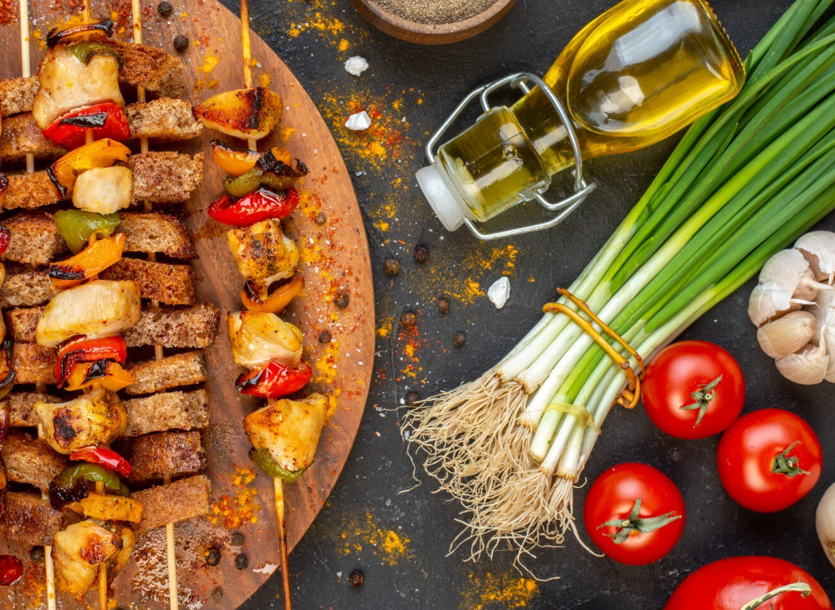 Attractively presented grilled chicken and vegetable skewers next to fresh ingredients