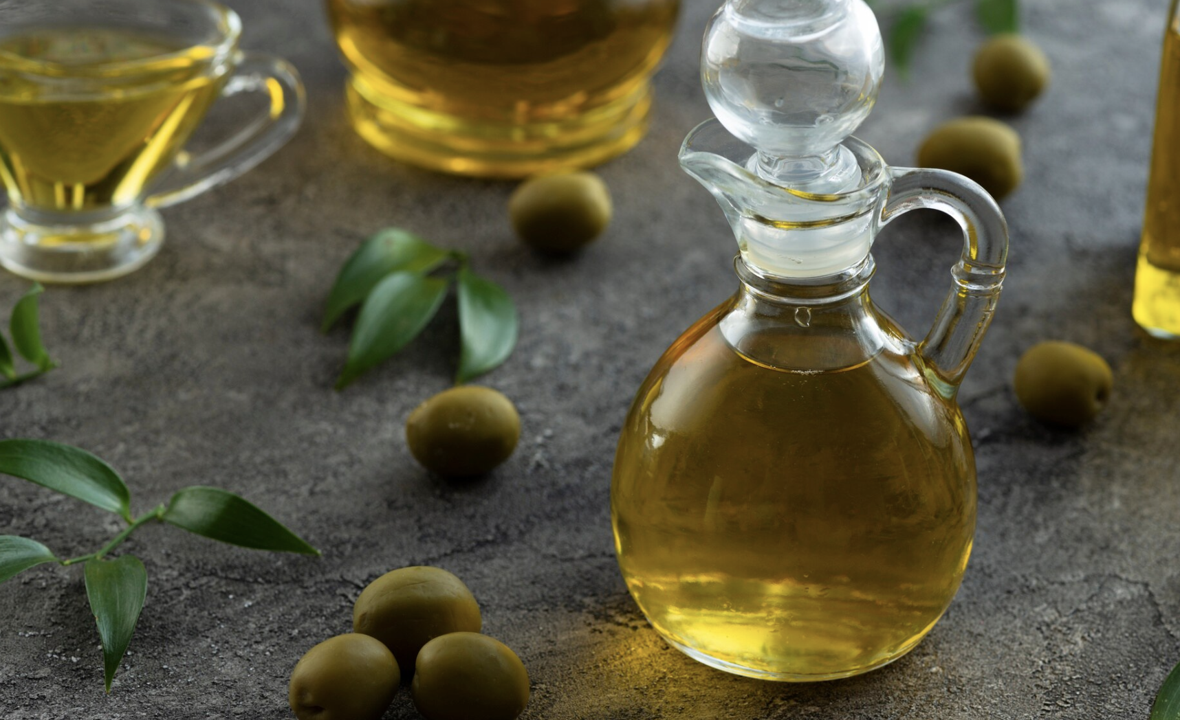 Olive oil bottle with raw olives